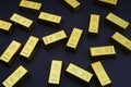 Scattered gold bars on the black table. Shiny precious metals for investments or reserves. Royalty Free Stock Photo