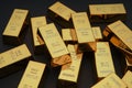 Scattered gold bars on the black table. Shiny precious metals for investments or reserves. Royalty Free Stock Photo