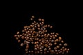 Scattered grains of roasted, fragrant coffee on a black background, isolation, flat-lay, copy space