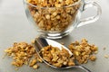 Scattered granola, spoon, muesli in cup on gray table Royalty Free Stock Photo