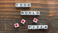 Scattered Letter Dice Spell Out Food Loves World Pizza on Wooden Surface Royalty Free Stock Photo