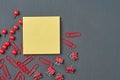 Scattered many binders, clips and pins near blank square paper for note on dark concrete desk in office, school or home. Space for Royalty Free Stock Photo