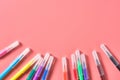 Scattered multi colored felt pens lies on pink desk in kindergarten