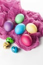 Scattered painted easter chicken and quail eggs on a white background with fuchsia gauze napkins Royalty Free Stock Photo