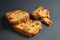 Scattered pieces of tasty sweet homemade bread with raisin lies on dark concrete table in kitchen Royalty Free Stock Photo