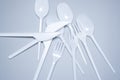 Scattered plastic forks knives spoons on a gray background close-up Royalty Free Stock Photo