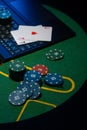 Scattered poker chips and cards on a green table with and laptop Royalty Free Stock Photo