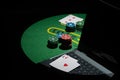 Scattered poker chips and cards on a green table with and laptop Royalty Free Stock Photo