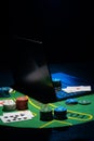 Scattered poker chips and cards on a green table with and laptop Royalty Free Stock Photo