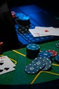 Scattered poker chips and cards on a green table with and laptop Royalty Free Stock Photo