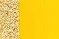 Scattered popcorn border left edge and empty space on yellow paper background. Top view Copy space Template for text or your