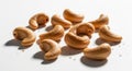 Scattered raw cashew nuts displayed on a white surface with soft shadows Royalty Free Stock Photo