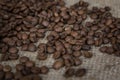 Scattered roasted coffee beans on burlap. Close-up Royalty Free Stock Photo