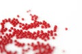 Scattered seed beads red color on a white surface Royalty Free Stock Photo