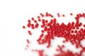 Scattered seed beads red color on a white surface Royalty Free Stock Photo
