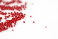 Scattered seed beads red color on a white surface Royalty Free Stock Photo
