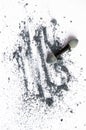 Scattered shiny powder blast, gray eyeshadow and makeup brush isolated on white background, vertical shot