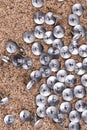 Scattered silver thumb tacks concentrated on the right side of a cork board Royalty Free Stock Photo