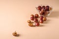 Scattered sliced half ripe sweet plum fruits with water drops near to plums in glass bowl on cream colored background Royalty Free Stock Photo