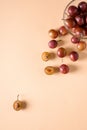 Scattered sliced half ripe sweet plum fruits with water drops near to plums in glass bowl on cream colored background Royalty Free Stock Photo