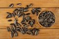 Scattered sunflower seeds, bamboo bowl with sunflower seeds on table. Top view Royalty Free Stock Photo