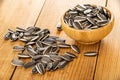 Scattered sunflower seeds and bamboo bowl with sunflower seeds on table Royalty Free Stock Photo