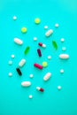 scattered various colored tablets in a blue-cyan background. View from above. close-up