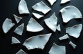Scattered white plate fragments on black background. Sharp broken ceramic pieces symbolize accidents conflict or failure. Royalty Free Stock Photo