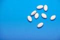 Scattered white tablets on a blue background Royalty Free Stock Photo