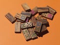 Scattered domino pieces on orange background Royalty Free Stock Photo