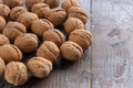 A scattering of beautiful ripe walnuts in unopened shells on a vintage wooden background.