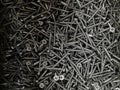 Scattering of black screws for wood. Construction Materials Royalty Free Stock Photo