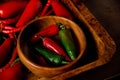 A scattering bunch of red chilies and green Romano peppers on a wooden tray. Colorful juicy hot peppers. Shot from above Royalty Free Stock Photo