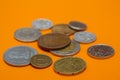 A scattering of coins on the orange background Royalty Free Stock Photo