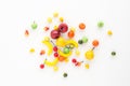 A scattering of many small different fruits on a white background. Mini copy, the concept of diversity of flavors and