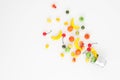 A scattering of many small different fruits on a white background. Mini copy of a metal bucket. The concept of diversity
