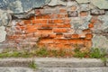 Scattering of plaster from the wall of an old house. Bright bricks. House destruction process