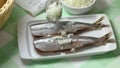 Scattering raw onions on fresh Dutch raw herring close up