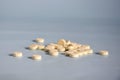 Scattering of round medicinal pills on gray background. Medicine concept of tablets, drugs, medicines and pills. Copy space.