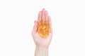 Scattering of transparent yellow pills. Handful of capsules in palm of hand, close-up, isolated on white background