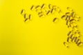 a scattering of yellow transparent fish oil capsules on a yellow background