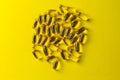 a scattering of yellow transparent fish oil capsules on a yellow background