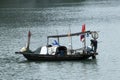 View of fishermen on small wooden boat tending net