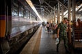 Bangkok, Thailand - March 6th 2020: A soldier in uniform stands out prominently on a platform in the Bangkok Railway Station. Royalty Free Stock Photo