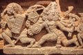 Scene with battles of ancient gods on stone sculptures of Hindu temple. India.