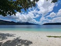 The scene on the beach of an island with turquoise water and blue sky with white clouds Royalty Free Stock Photo