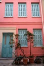 Scene of beautiful urban building facade background in pastel pink plaster paint wall, light blue entry door and window shutter Royalty Free Stock Photo