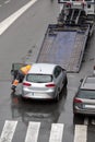 Scene of a broken down car on a city street road ready to load to the platform of flat bed tow truck Royalty Free Stock Photo