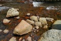 Scene of clear fresh water stream flow through natural river hard rock with lichen, small wave and light reflection background Royalty Free Stock Photo