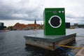 Denmark, Copenhagen - July 03, 2023: A green washing machine on a concrete barg is the Obel Award unPAVILION. Royalty Free Stock Photo